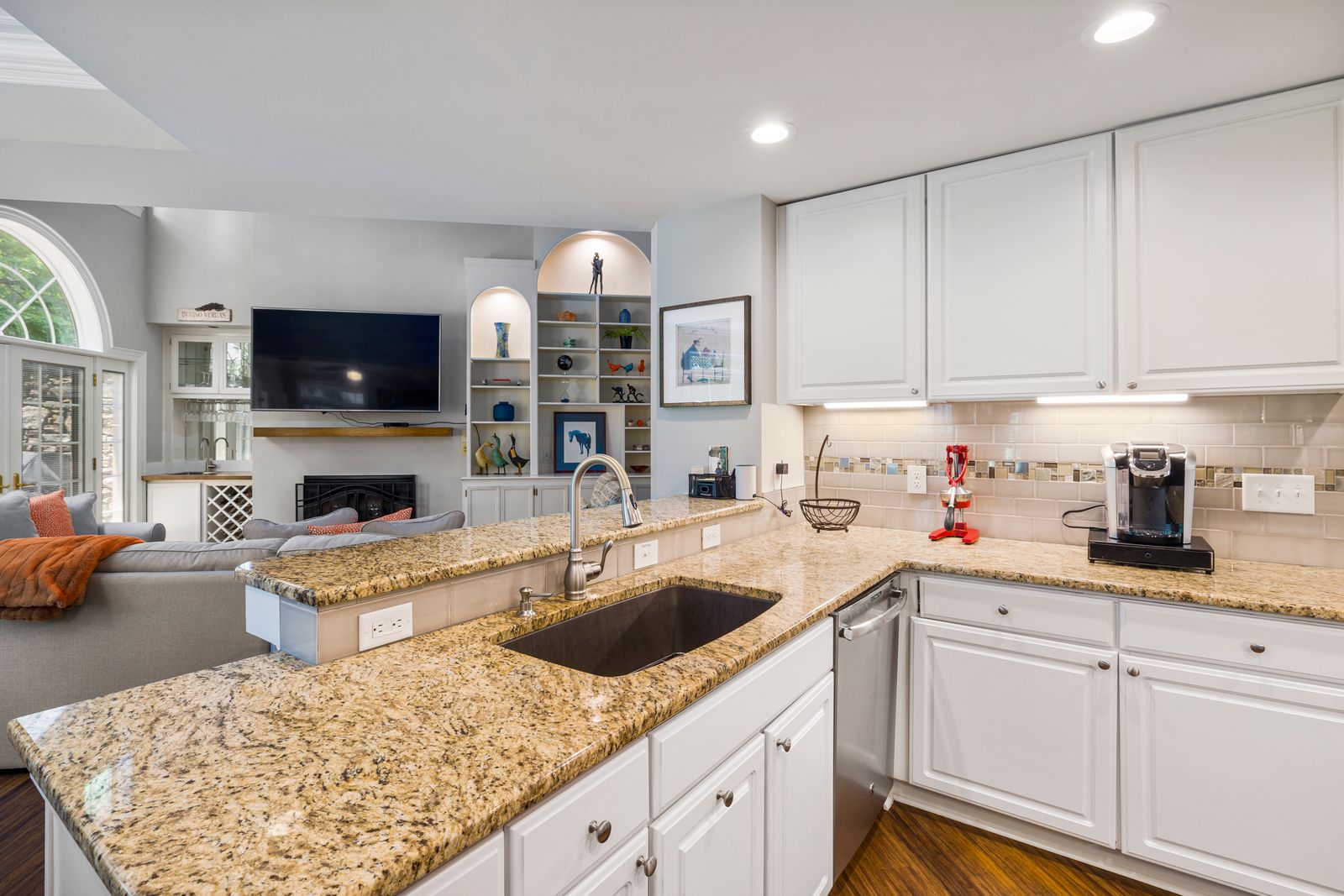 Renovated kitchen with granite counters open to the living room