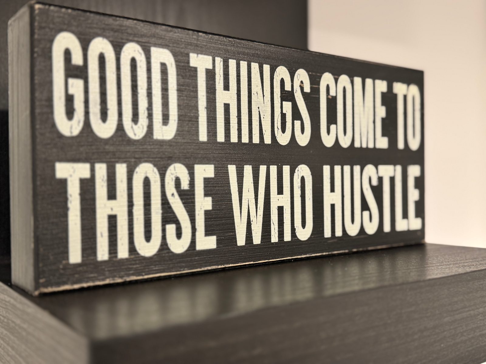 A sign reading: Good things come to those who hustle